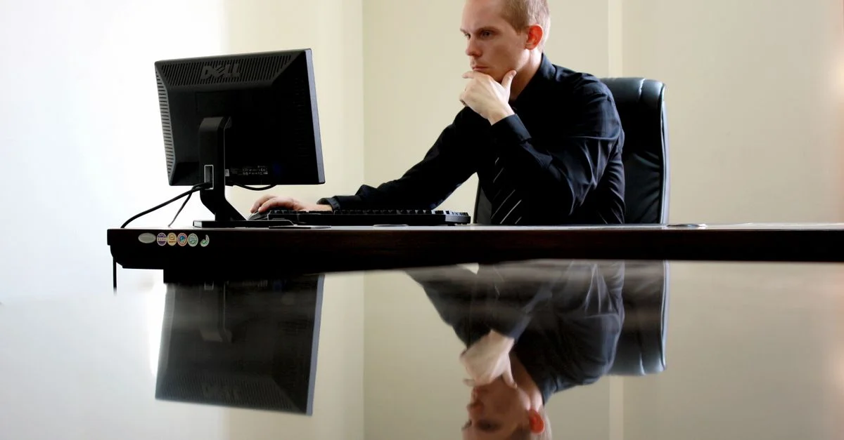 Un homme d'affaires en pleine réflexion à son bureau, réfléchissant à ses tâches professionnelles.