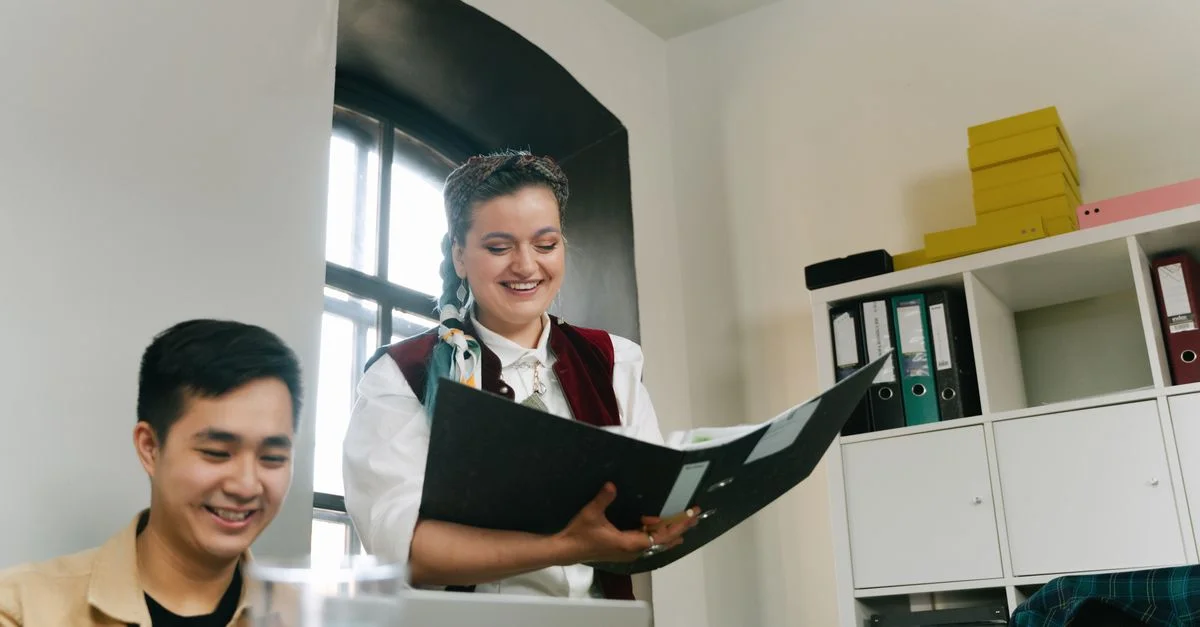 Des collègues collaborant dans un bureau lumineux, discutant de stratégies avec le sourire.