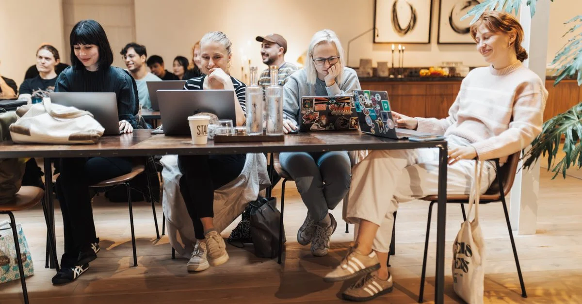 Groupe d'adultes dans un cadre de bureau moderne collaborant sur des ordinateurs portables. Travail d'équipe dynamique.