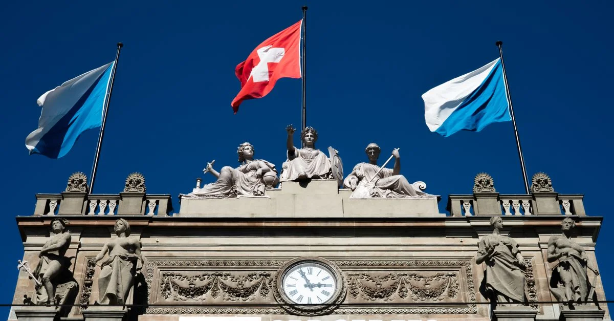 Bâtiment historique SBB avec des drapeaux suisses et des sculptures à Zurich.