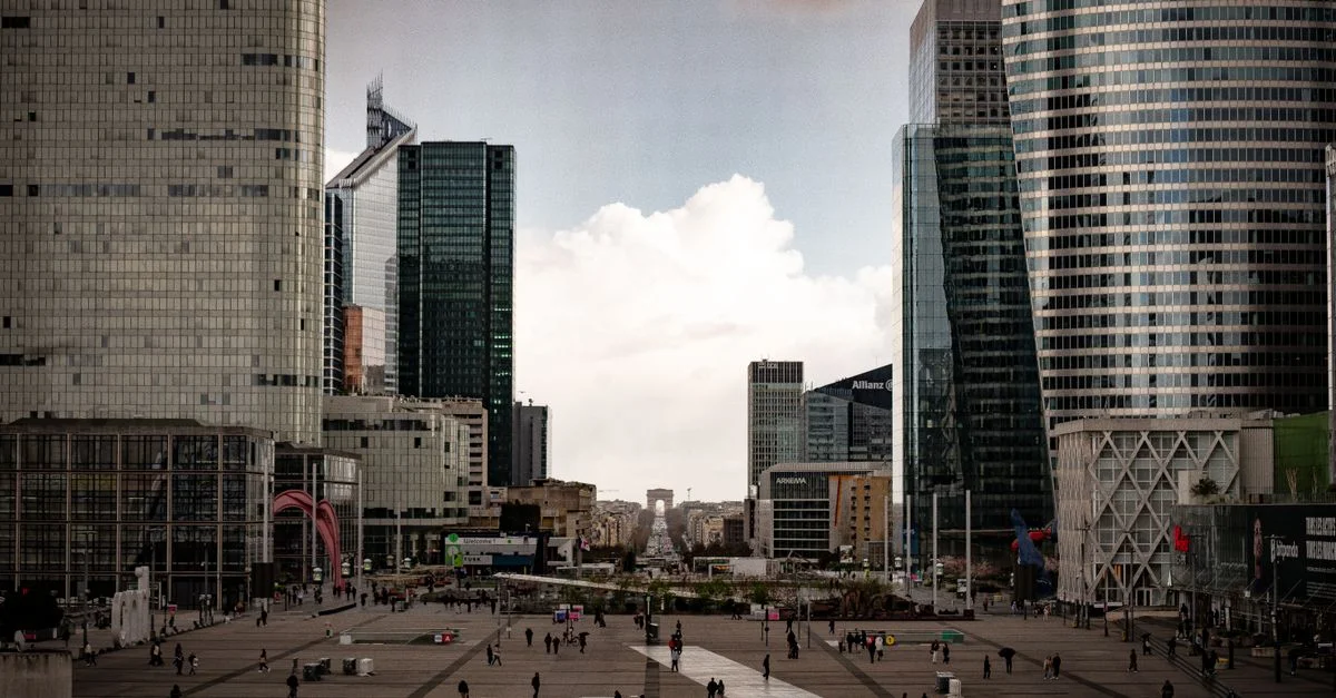 Scène urbaine animée mettant en valeur les gratte-ciel et les passants à La Défense, Paris.