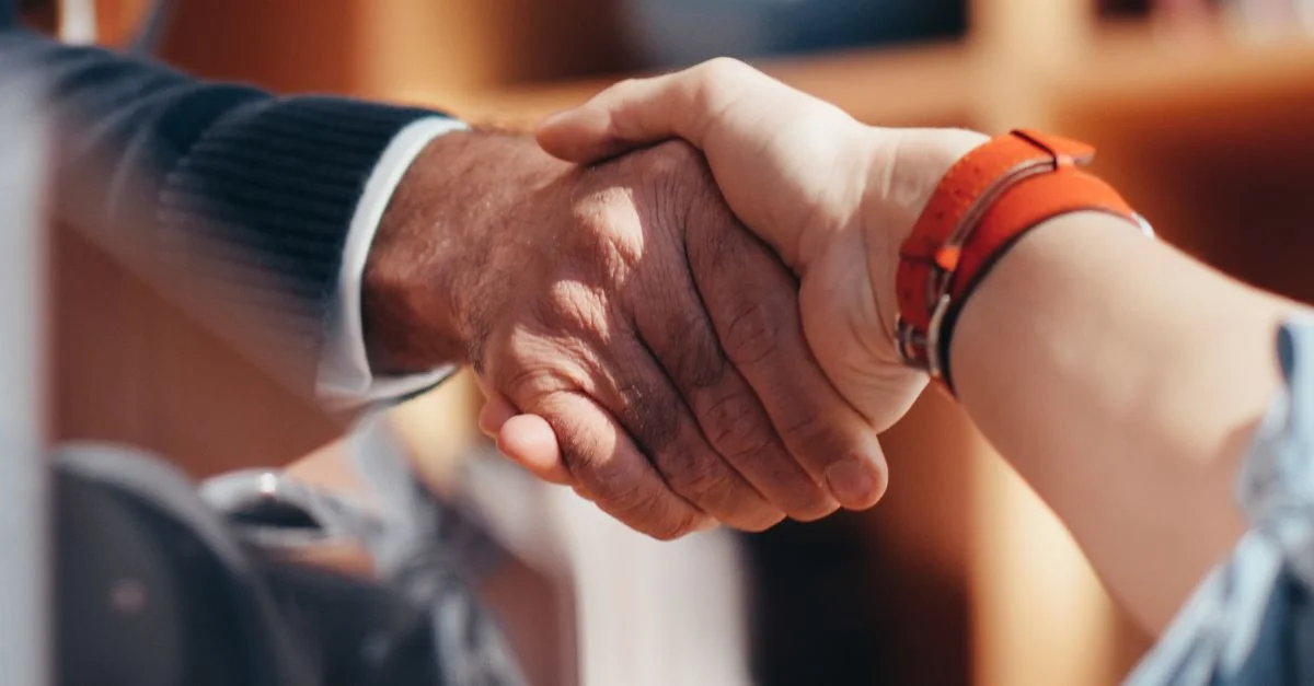 Une image en gros plan de deux personnes se serrant la main, symbolisant un accord commercial.