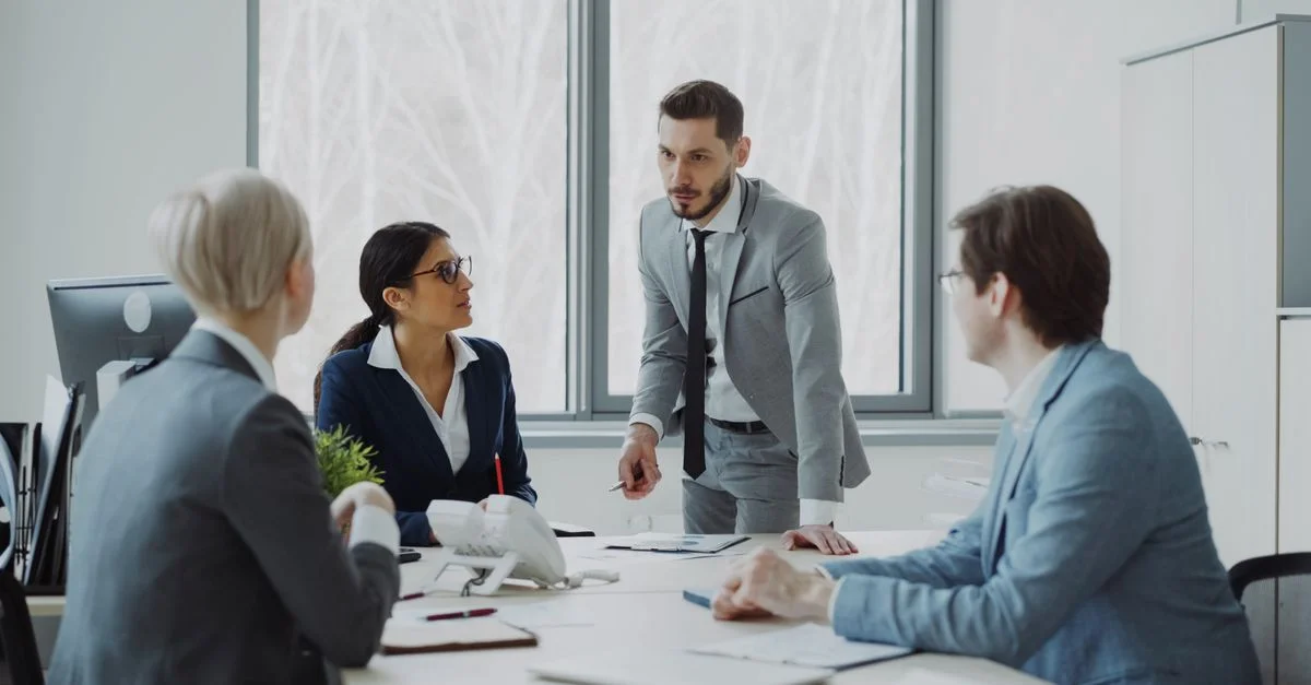 Des professionnels engagés dans une discussion sérieuse dans un environnement de bureau lumineux.