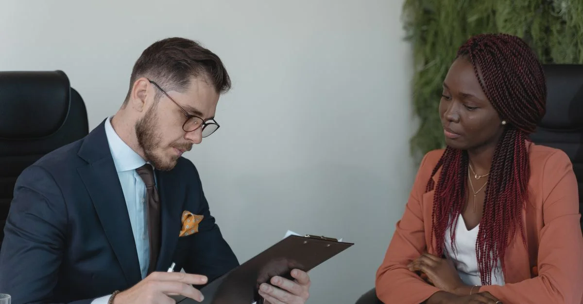 Un homme et une femme participant à un entretien d'embauche dans un bureau moderne.